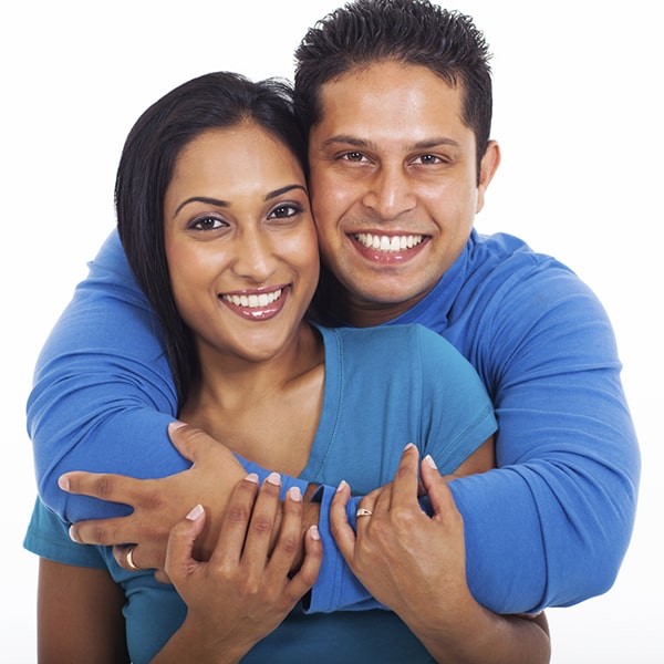 A woman hugging a man with arms around him.